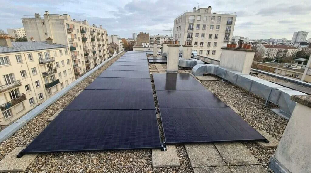 immense toiture couverte de panneaux vue du ciel — Copropriétés mixtes (résidence + commerces)